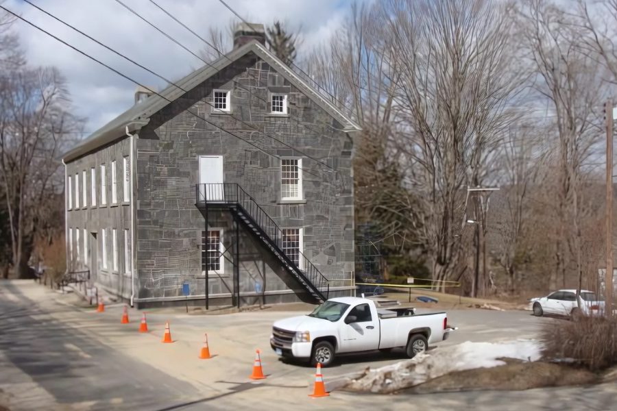 Haddam's stone old town hall during restoration, with work vehicles and safety cones