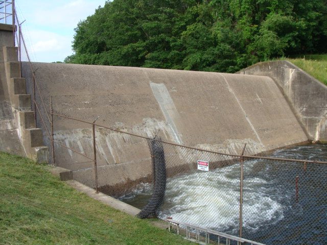 Concrete spillway training wall with flow below