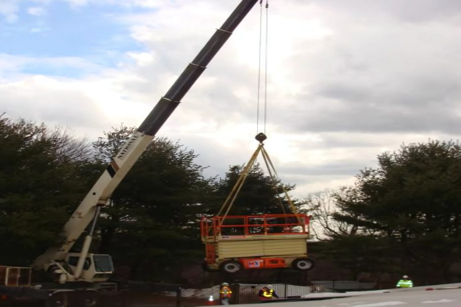Truck crane lifting a scissor lift over the Mill Rock Basin roof