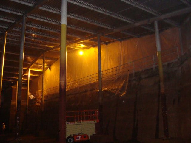 Scissor lift working inside the basin beneath the roof framing