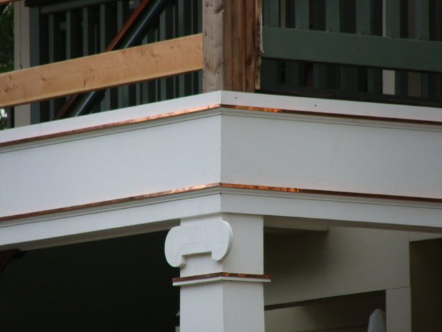 New copper cap flashing at a porch column and beam